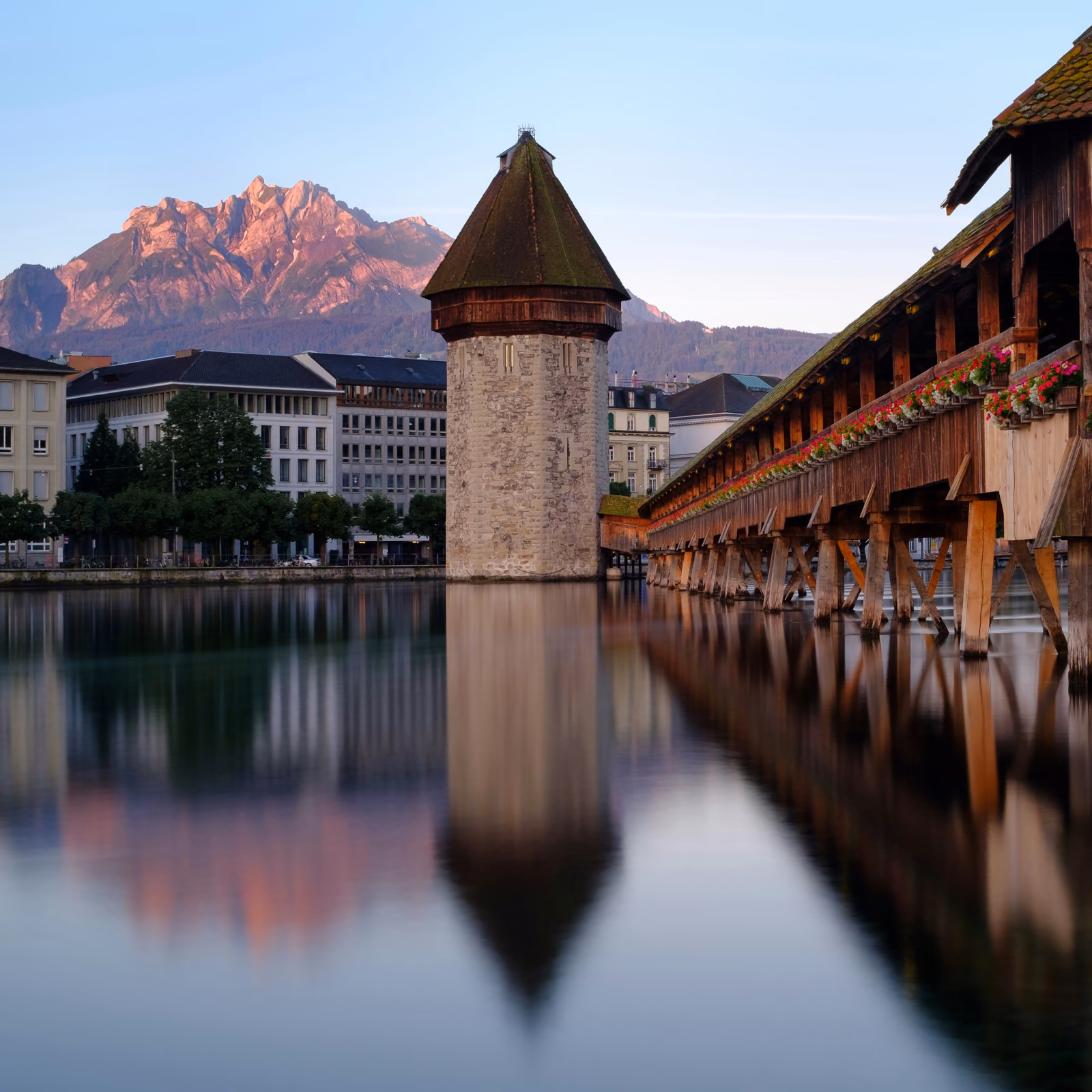 Kapellbrücke und Wasserturm in Luzern im Abendlicht, dahinter der Pilatus